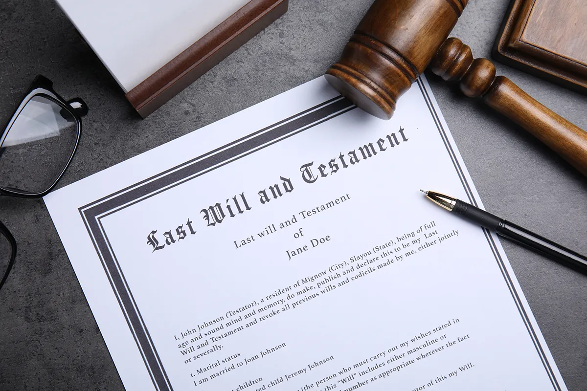 A close-up of a hand signing a document at a desk